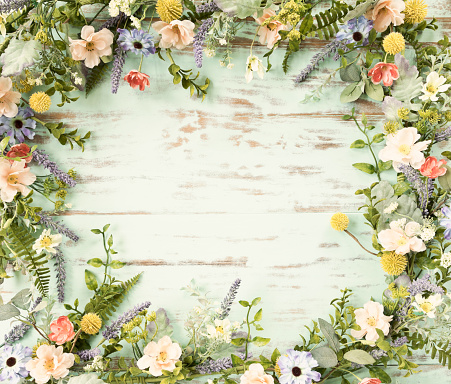 istock Spring flower wreath garland frame on an old rustic blue wood background 1312304368