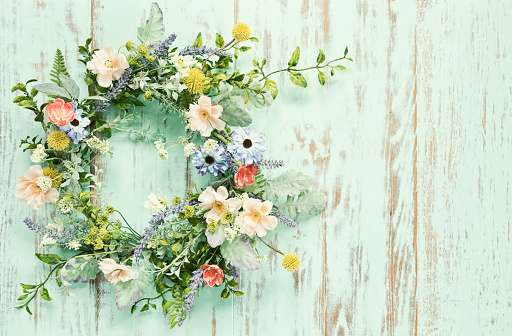 Spring Flower wreath on an old rustic blue/green wood background