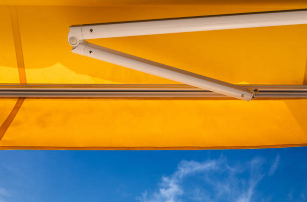 istock yellow awning canvas against blue sky. exterior shading roof. 1312305513