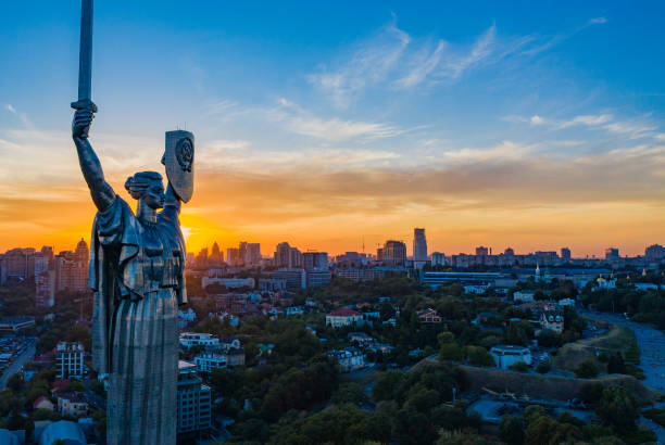 Aerial view to the Motherland statue in the Kiev while  summer sunset. The well-known landmarks in Kyiv. Historical monument of Soviet union. Beautiful city Kiev while sunset. stock photo