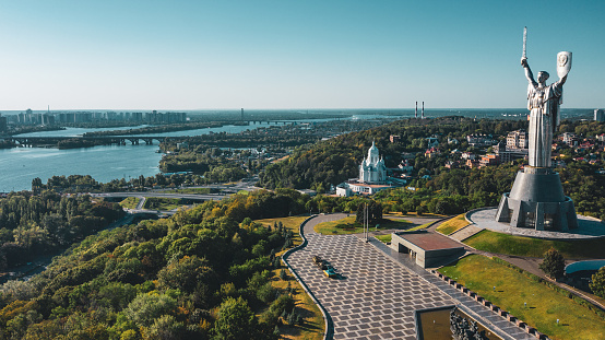 Aerial view to the  Beautiful landscape city Kiev with a Dnepr river. Top view to the Motherland statue in the Kiev. The well-known landmarks in Kyiv. Historical monument of Soviet union.