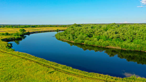 vue aérienne d’un beau paysage d’été au-dessus de fleuve tandis que l’aube. vue supérieure au-dessus de la rivière avec une surface lisse d’eau reflétant le ciel bleu. - horizon over water horizontal surface level viewpoint photos et images de collection