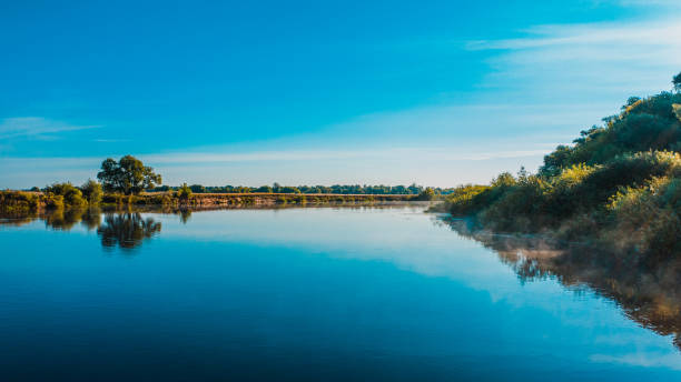 vue aérienne d’un beau paysage d’été au-dessus de fleuve tandis que l’aube. vue supérieure au-dessus de la rivière avec une surface lisse d’eau reflétant le ciel bleu. - horizon over water horizontal surface level viewpoint photos et images de collection