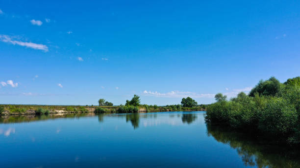 vue aérienne d’un beau paysage d’été au-dessus de fleuve tandis que l’aube. vue supérieure au-dessus de la rivière avec une surface lisse d’eau reflétant le ciel bleu. - horizon over water horizontal surface level viewpoint photos et images de collection