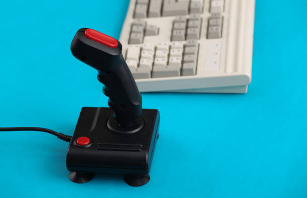 istock Old pc keyboard and joystick on blue background. Retro gaming. 80s. 1312307308