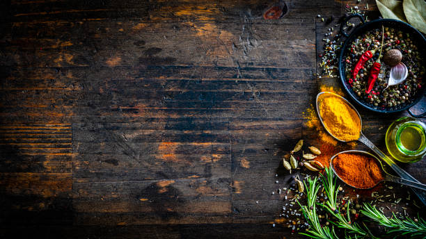 istock Scented spices and herbs border on dark table 1312307402
