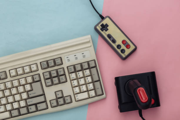 istock Old keyboard, joystick and gamepad on blue pink background. Retro gaming. 80s. Top view. Flat lay 1312308856