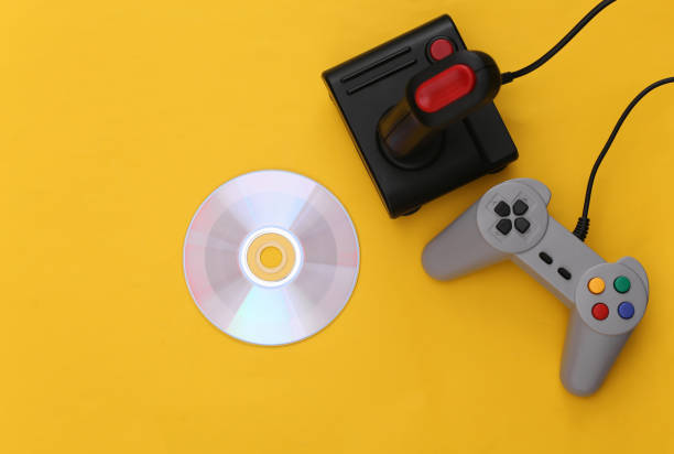 istock Retro joystick and gamepad, CD on yellow background. Gaming, video game competition. Top view, minimalism 1312308880