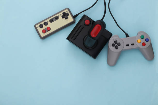 istock Retro gamepads and joysticks on blue background. Video game, gaming 80s. Flat lay, top view. Copy space 1312308899