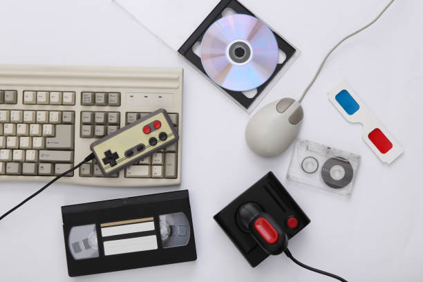 istock Flat lay 80s attribute composition. PC keyboard, mouse, gamepads, audio and video tapes, CD, 3D glasses. Retro Electronics, gadgets and devices. Entertainment and gaming. White background. Top view 1312308993