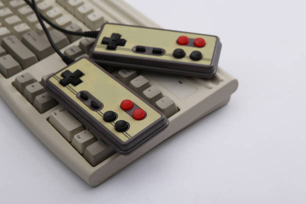 istock Two retro gamepads and old pc keyboard on white background. Gaming, video game competition. 1312309107