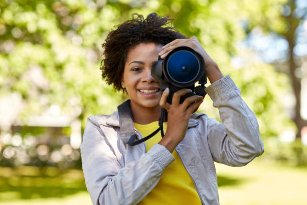 istock happy african woman with digital camera in park 1312310367