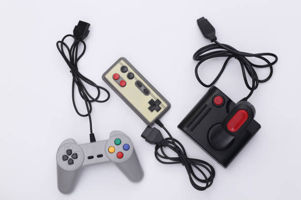istock Wired retro gamepads and joystick with wound cable on white background. Video game, gaming. Top view 1312310558