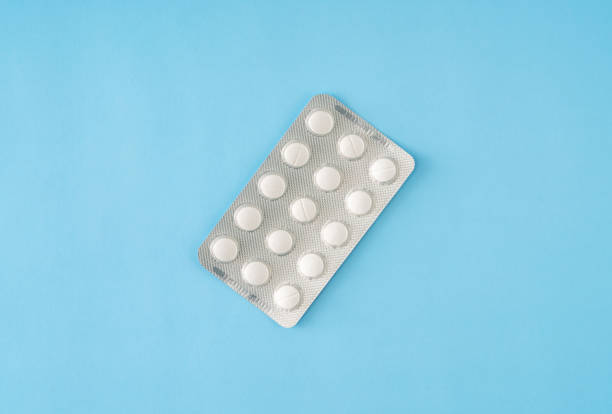 pill blister pack on blue background - birth control pill imagens e fotografias de stock