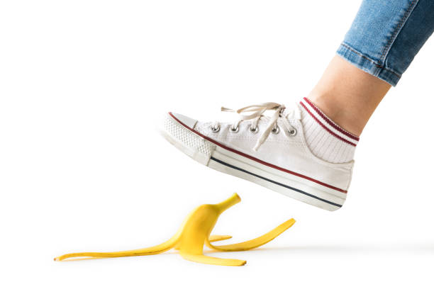 Woman stepping on Slippery Banana Peel stock photo