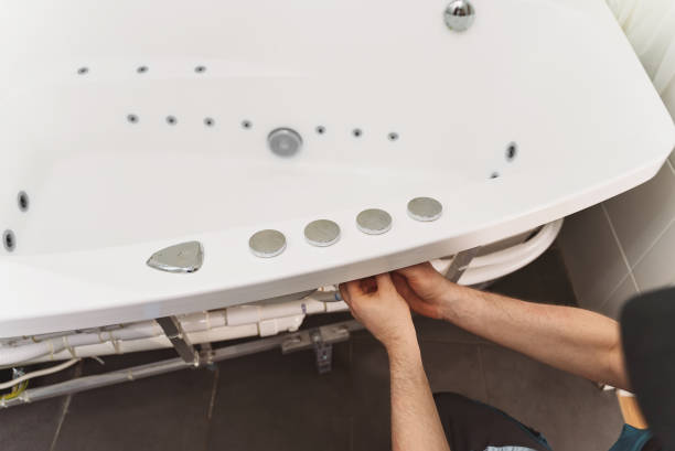 istock Man installing pipe system of bathtub with hydromassage. 1312311830
