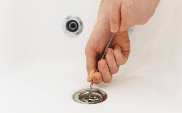 istock Plumber using drain snake to unclog bathtub. 1312311839