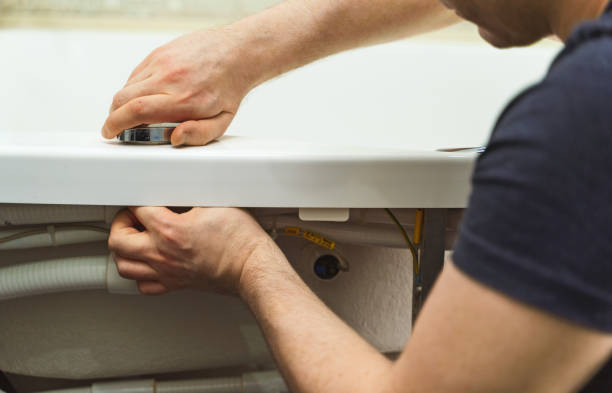 istock Man installing pipe system of bathtub with hydromassage. 1312311858