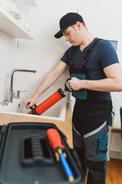 istock Plumber unclogging kitchen sink with professional force pump cleaner. 1312311882