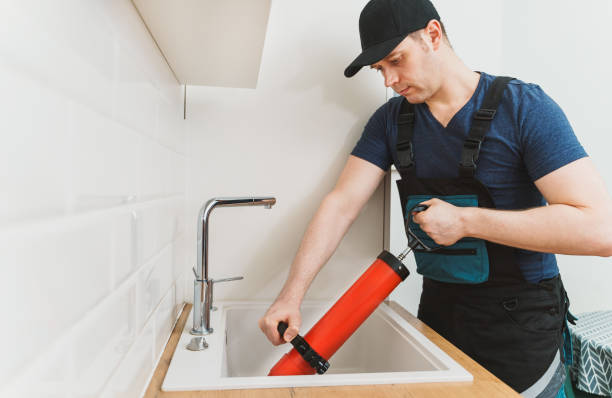istock Plumber unclogging kitchen sink with professional force pump cleaner. 1312311883