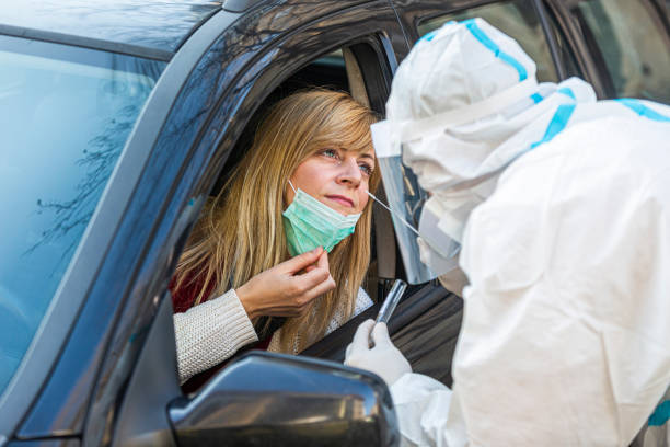 istock Medical worker in PPE performing drive-thru COVID-19 test 1312313555