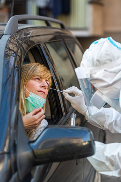 istock Medical worker in PPE performing drive-thru COVID-19 test 1312313690