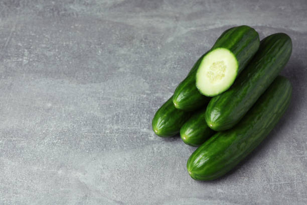 istock Ripe cucumbers on gray background, space for text 1312313922