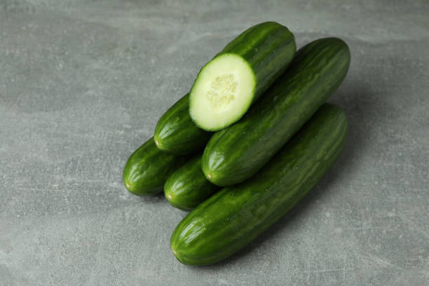 istock Ripe cucumbers on gray background, close up 1312314687