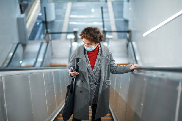 femme affichant un message texte restant sur les étapes d’escalator - railroad station escalator staircase steps photos et images de collection