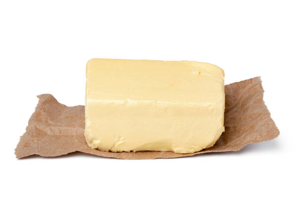 istock Fresh butter on craft paper isolated on white background 1312316126