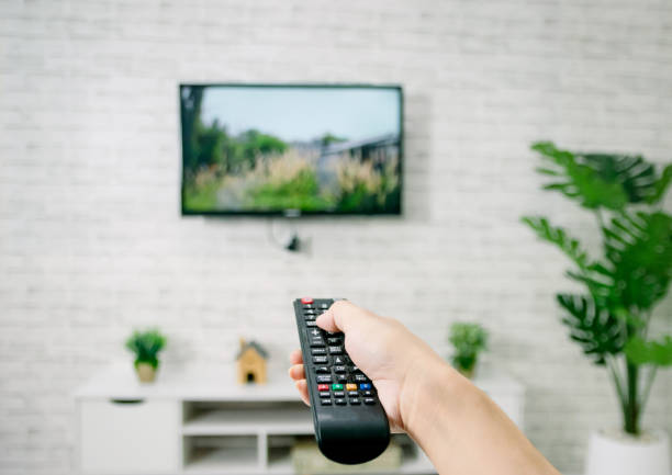 istock Hand hold living room tv remote control 1312316289