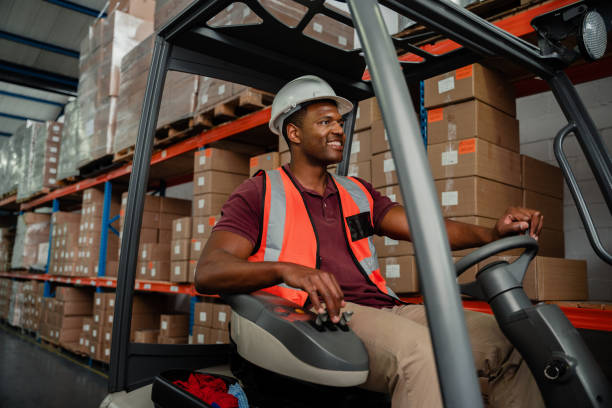 istock Ethnic worker driving forklift in warehouse locating delivery parcels 1312316414