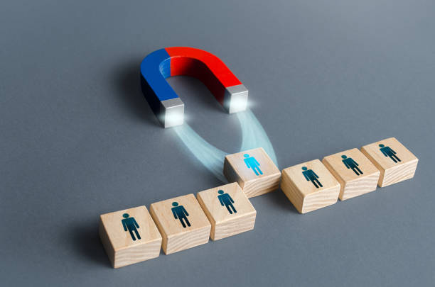 istock Magnet pulls a person out of row blocks. Choosing best candidate for hiring. Competition for a working high position of a manager. Poaching participants from other company team. Luring concept 1312316792