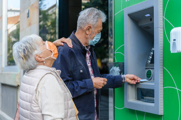 istock A Couple of Seniors are Using ATM During a Virus Time. 1312317469
