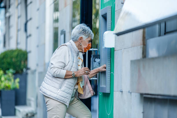istock Senior Woman is Using ATM During a Pandemic Time. 1312317490
