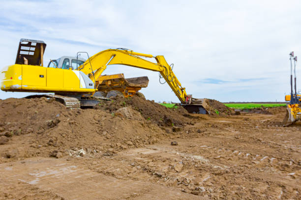 istock Excavator is loading a truck with ground on building site 1312317798