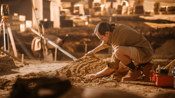 istock Archaeological Digging Site: Great Male Archeologist Work on Excavation Site, Carefully Cleaning, Lifting Newly Discovered Ancient Civilization Cultural Artifact, Historic Clay Tablet, Fossil Remains 1312318677