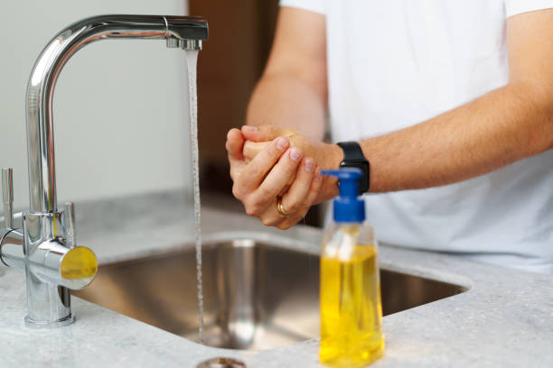 istock Man washing hands with soap in a sink at his home 1312318857