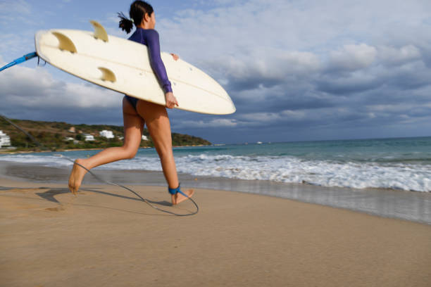 istock Woman surfer run in ocean with surfboard 1312321535