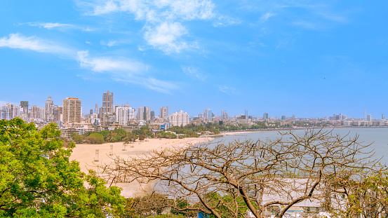 A view of Mumbai's Marine Drive from Malabar Hills. The Queen's Necklace. Long shot with a blue sky with clouds.