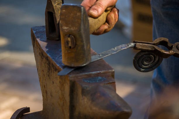istock blacksmith performs the forging of hot glowing metal on the anvil 1312323624