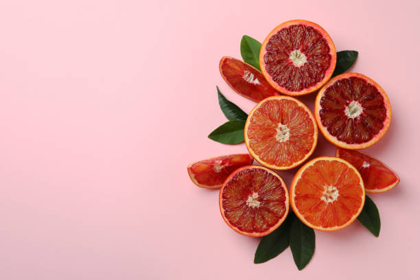 istock Red oranges and leaves on pink background 1312323776