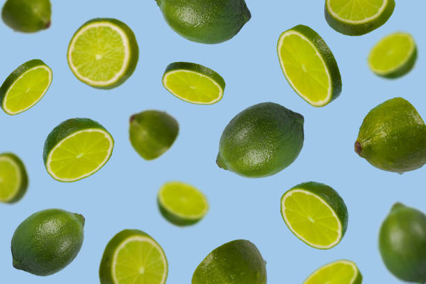 istock Falling limes isolated on a pastel blue background, Minimal concept 1312323797