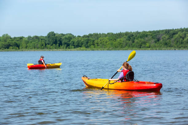 istock Two Young Girls Kayaking on Lake in Summer 1312325295