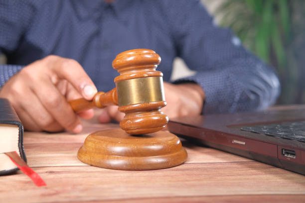 istock close up of person's hand striking the gavel. 1312325395