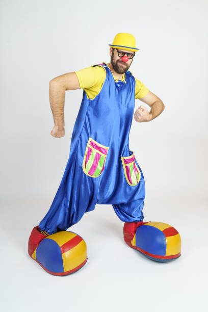 istock A clown in a bright blue and yellow suit shows off his muscles 1312330258