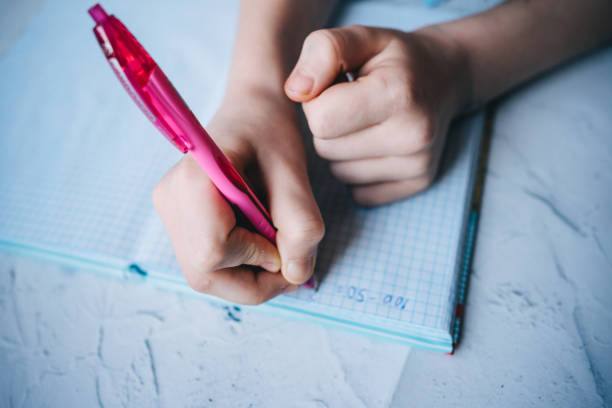 istock girl writes in a notebook with a pink pen 1312330603