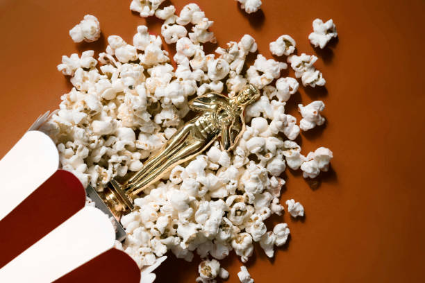 Souvenir golden statuette lies in popcorn on a red background.