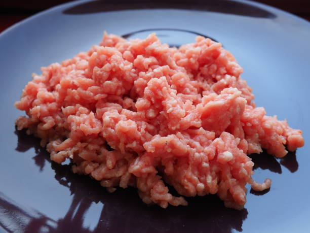 istock Minced meat on a purple ceramic large plate. Delicious fresh ground meat for making cutlets, steaks, hamburgers, meatballs. Pork semi-finished products 1312330912