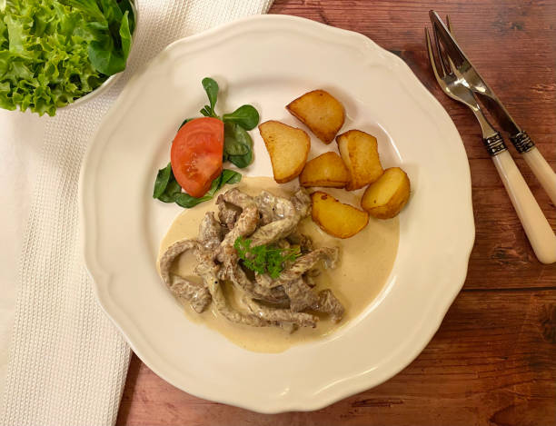 istock Skillet roasted beef steak strips in garlic cream sauce with crispy pan fried potatoes. 1312331847